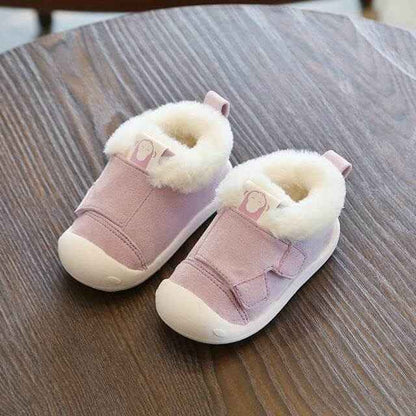 Velvet and cotton toddler shoes with non-slip soles on a wooden table.