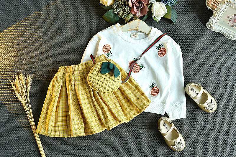 Embroidered sweater and yellow plaid skirt suit ensemble with accessories.