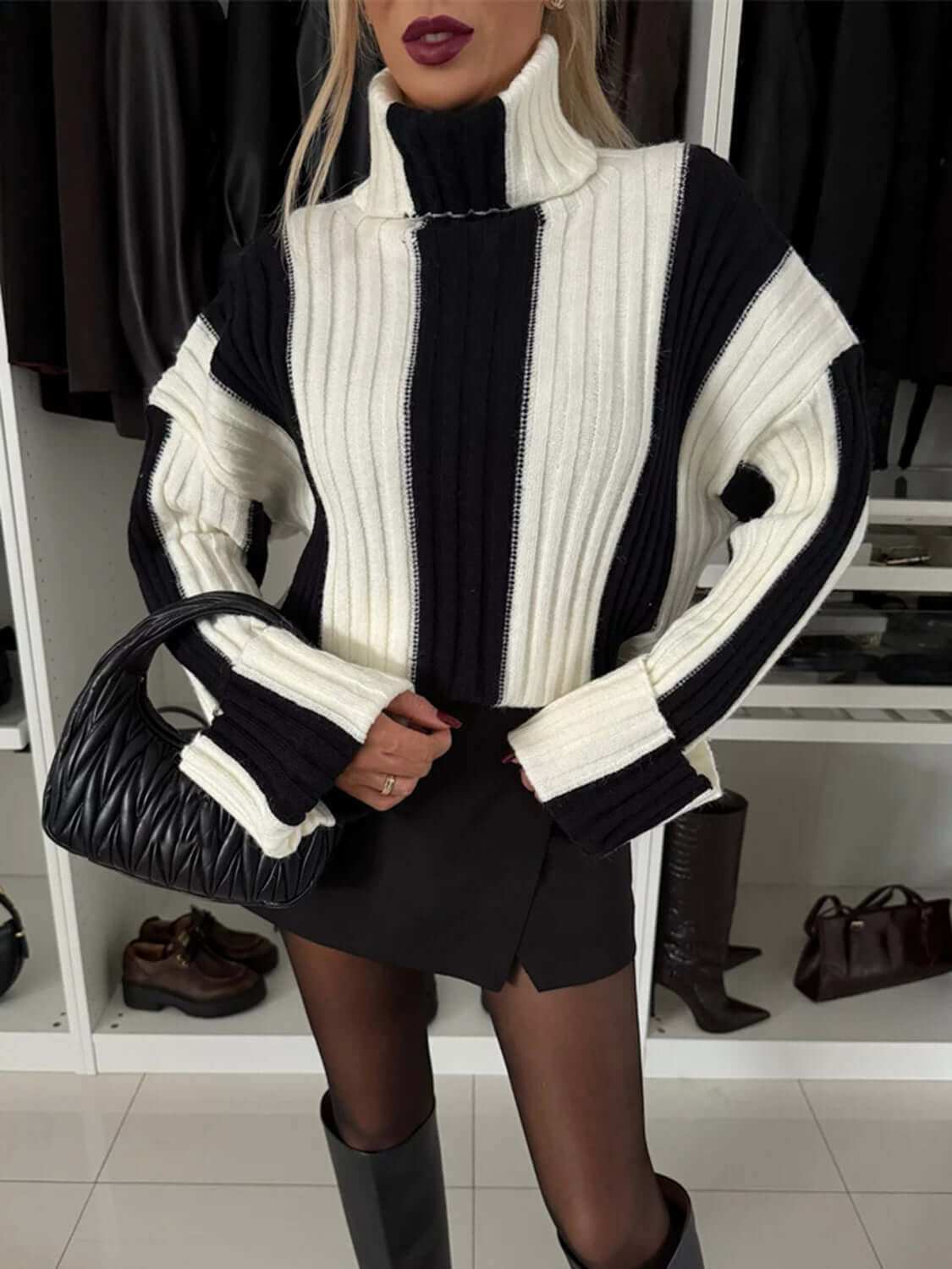 Striped turtleneck dropped shoulder sweater on model with black and white pattern.