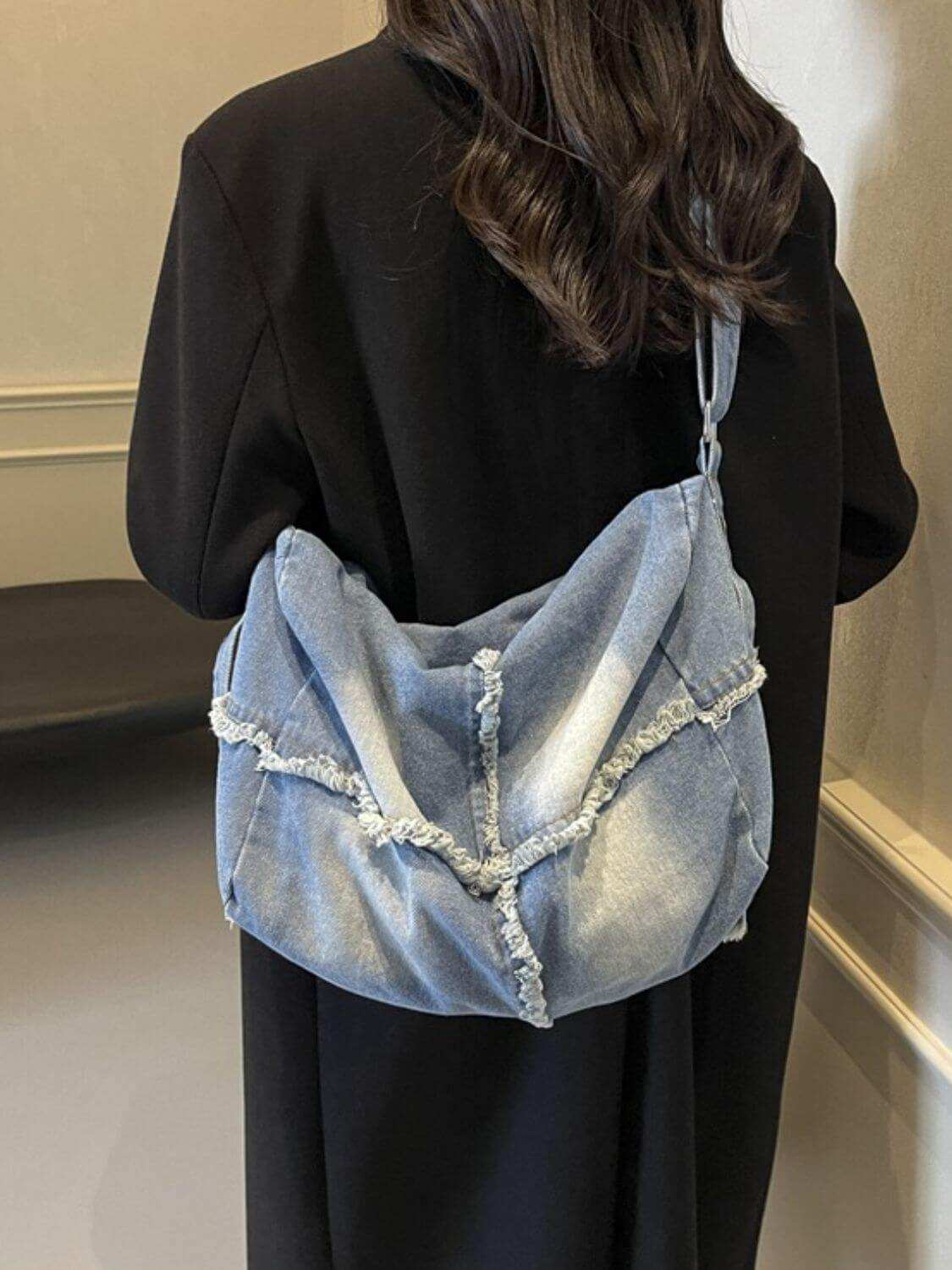 Raw Hem Gradient Crossbody Bag in denim with spacious interior, worn by a woman.