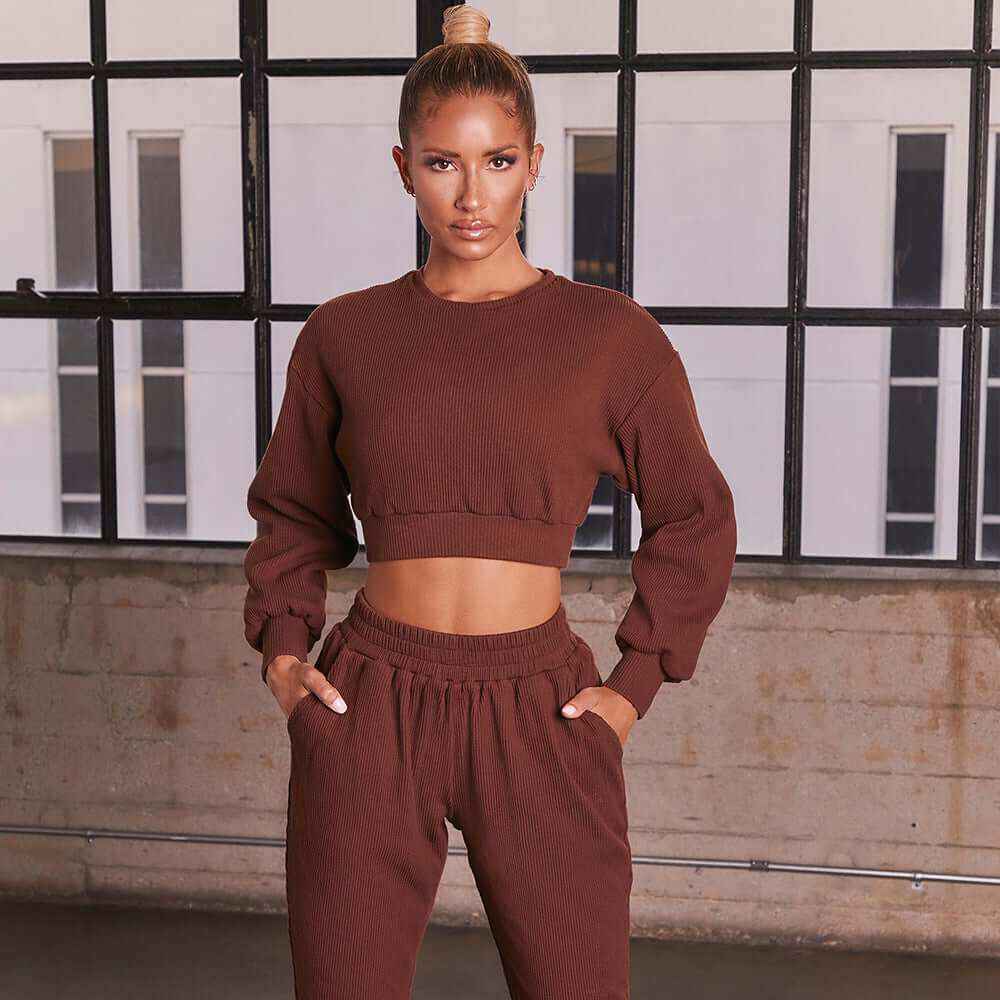 Woman wearing Plush Fashions casual sweat suit in brown, featuring a fleece sweater and straight pants.