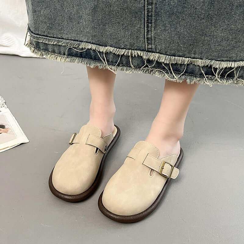 Suede round toe slip-ons for women's with buckle detail, shown on feet, paired with a denim skirt.