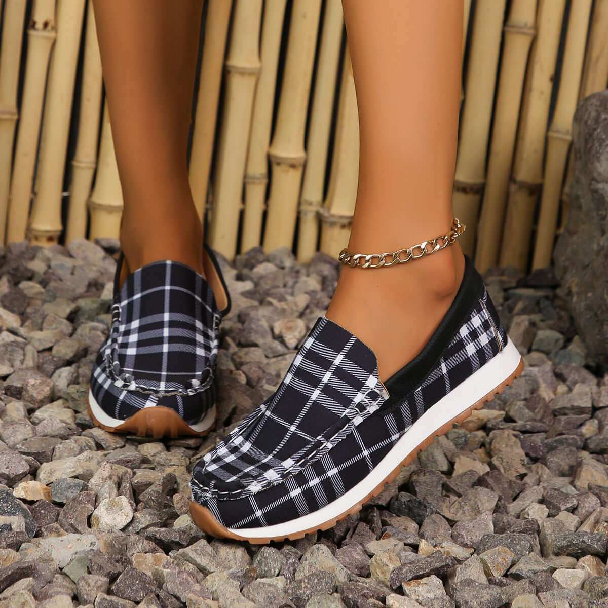 Plaid Round Toe Slip-Ons on rocky surface, featuring durable elastomer and soft polyester material for comfort and style.