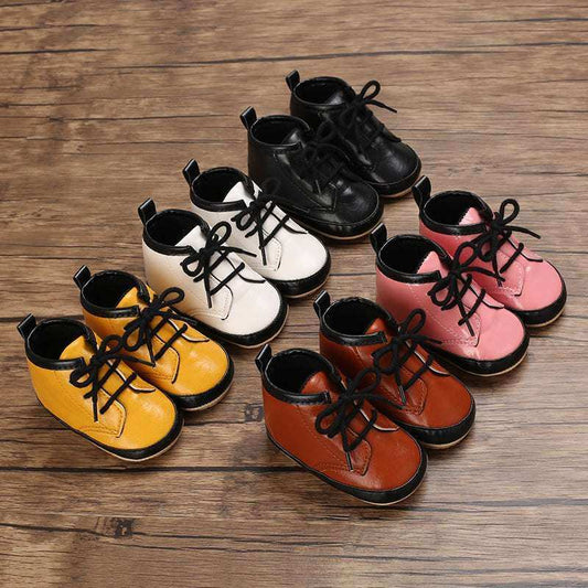 Boys baby casual soft soles shoes in various colors including white, yellow, black, pink, and brown, displayed on a wooden floor.