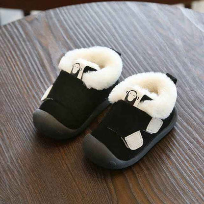 Velvet and cotton toddler shoes with non-slip soles on wooden table.