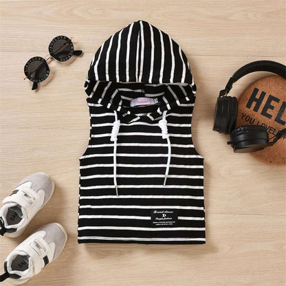 Boys' hooded striped tank top and shorts set with sneakers and accessories on wooden background.