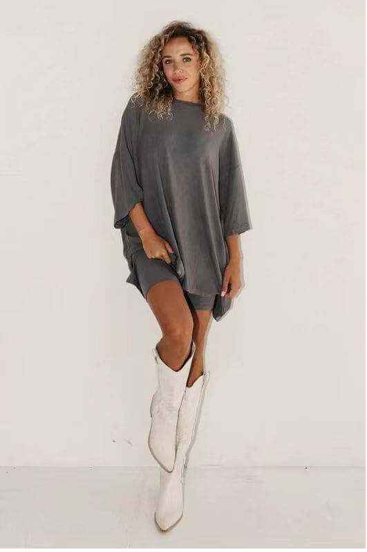 Women's solid color loose T-shirt and tight shorts set with white boots.