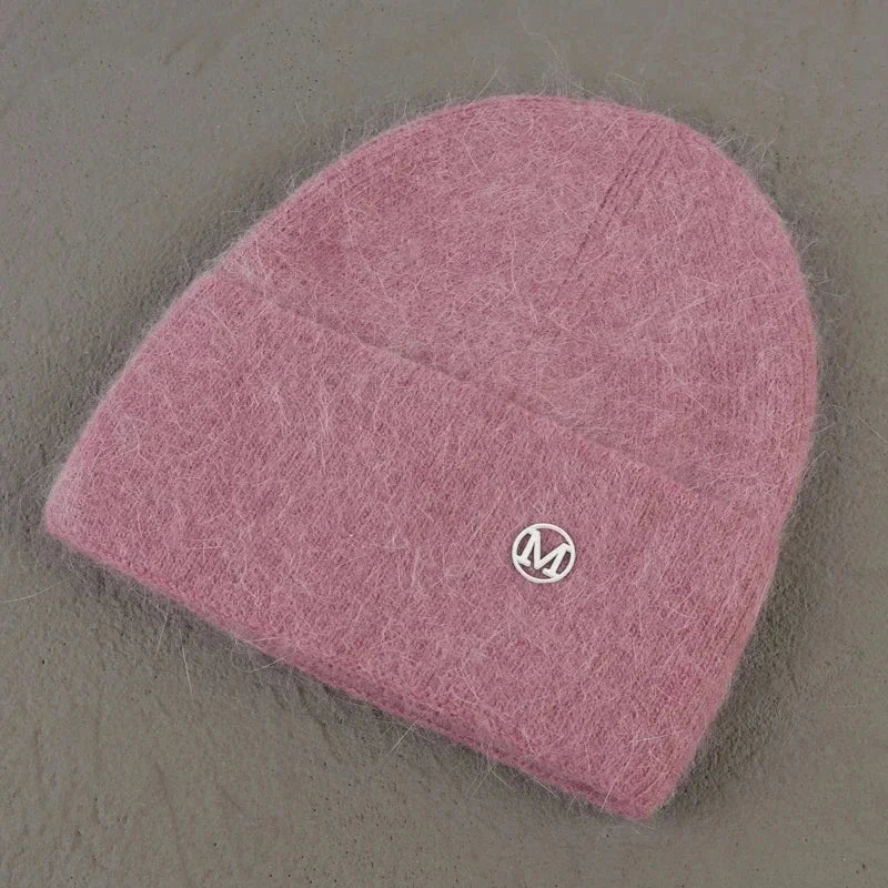 Women solid color fur knitted bonnet beanie in soft pink, ideal for warmth and style during winter.