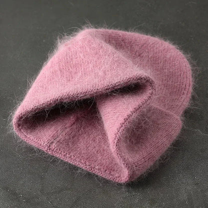 Women's pink solid color fur knitted bonnet beanie for warmth and style.