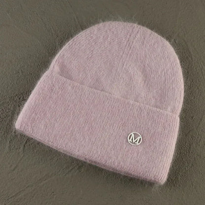 Women solid color fur knitted bonnet beanie for winter warmth and style.