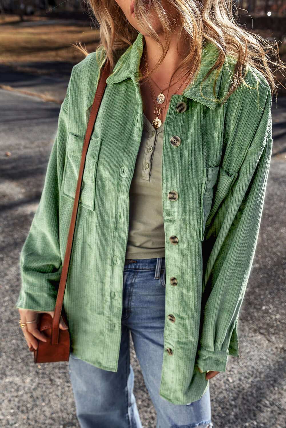 Pocketed collared neck button-up shacket in green worn by a person outdoors.