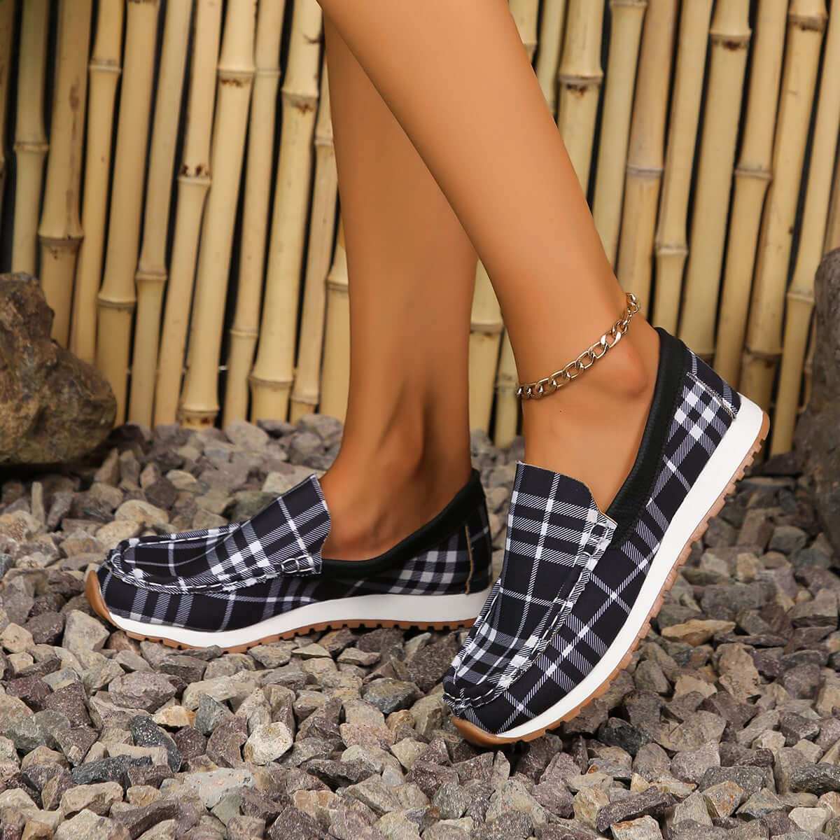 Plaid Round Toe Slip-Ons on gravel path, durable elastomer and soft polyester material.